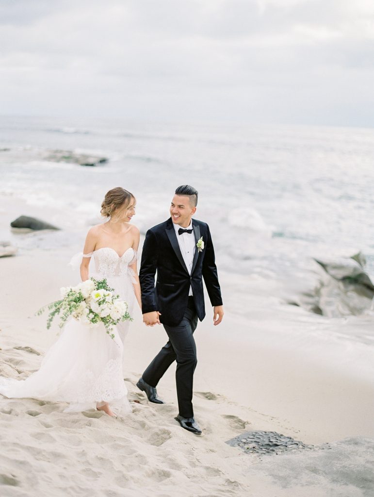 Darlington House in La Jolla wedding bride and groom walking on beach photo